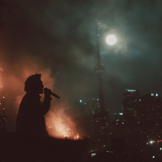 Person singing into a microphone with city skyline and fireworks in the background