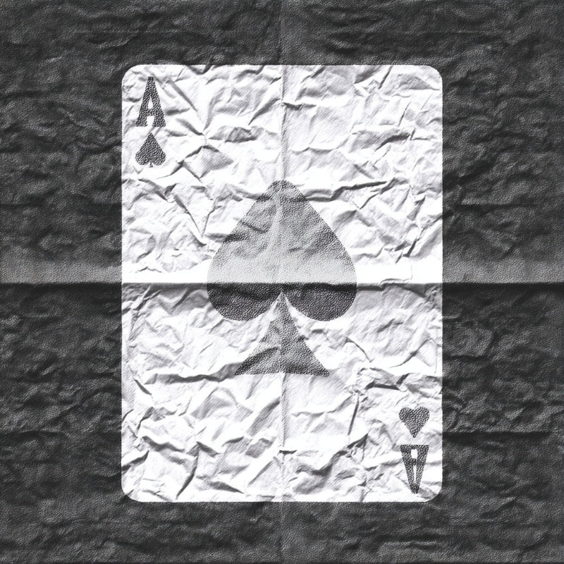 Crumpled playing card with Ace of Spades on a textured surface