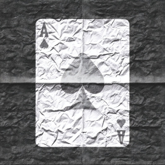 Crumpled playing card with Ace of Spades on a textured surface