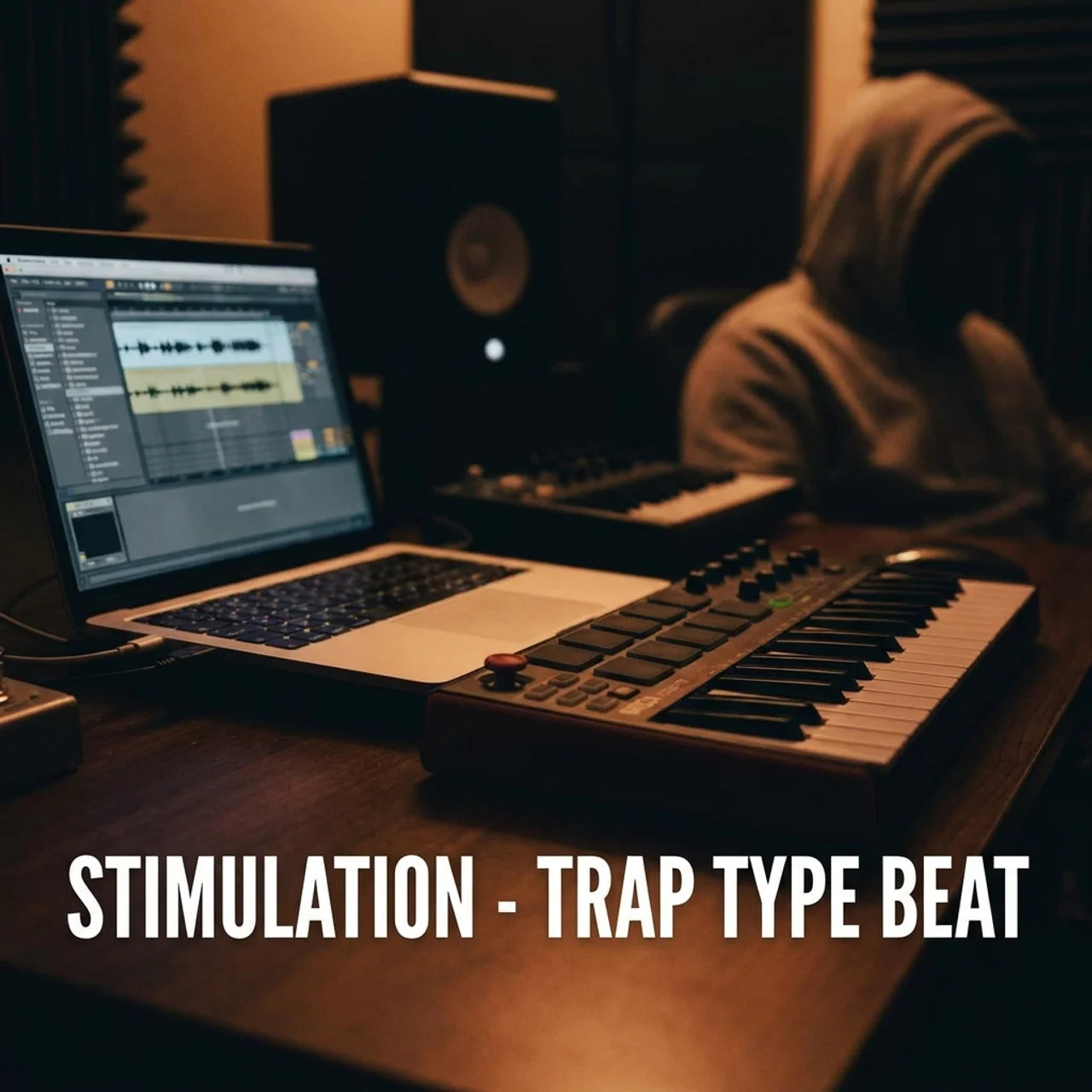 Music production setup with laptop, mixer, and speakers in a dimly lit room.