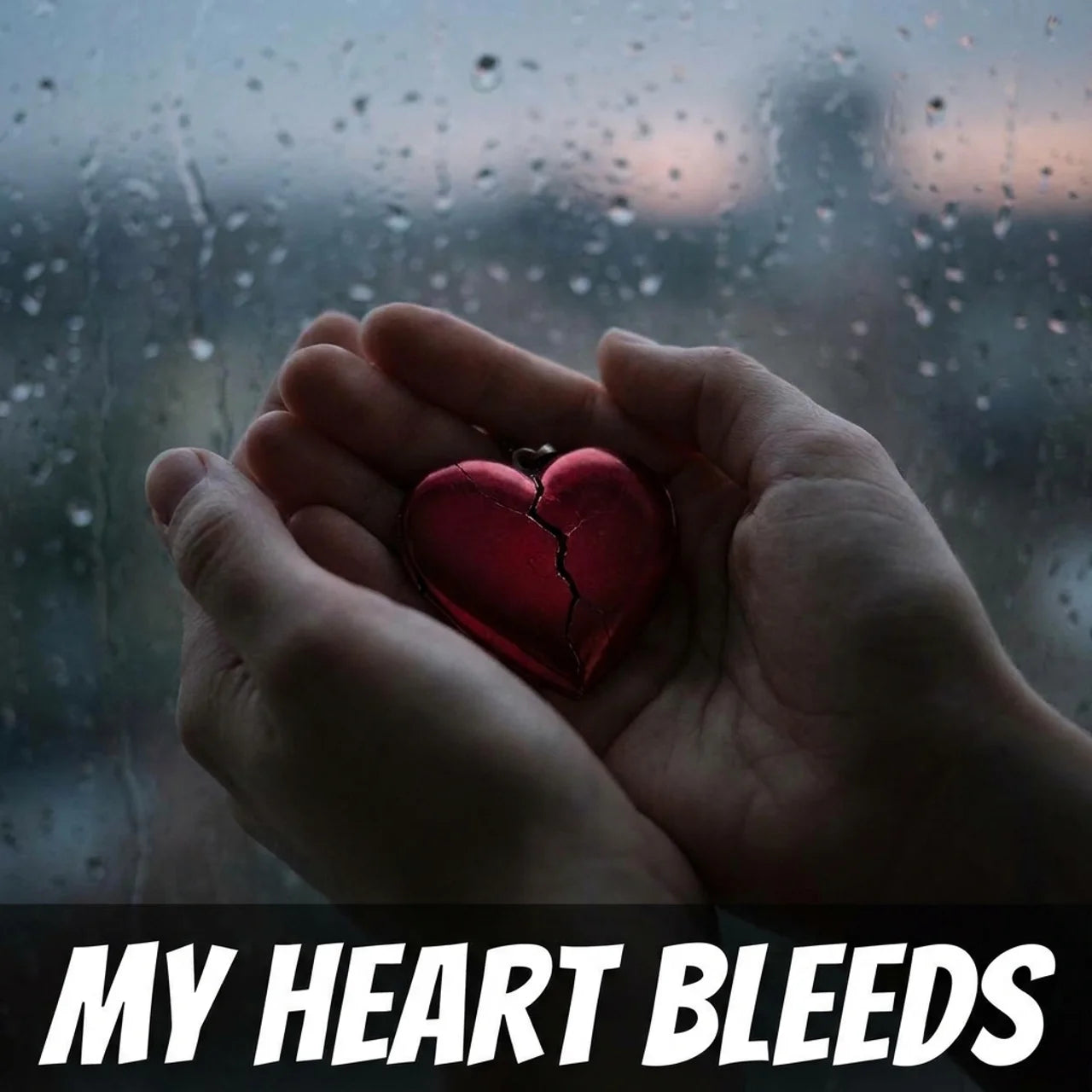 A pair of hands holding a small red heart-shaped locket with a visible crack, set against a rain-splattered window background. The text 'MY HEART BLEEDS' appears in bold white letters at the bottom.