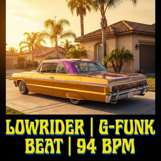 Yellow and purple lowrider car parked in a driveway with palm trees and a house in the background.