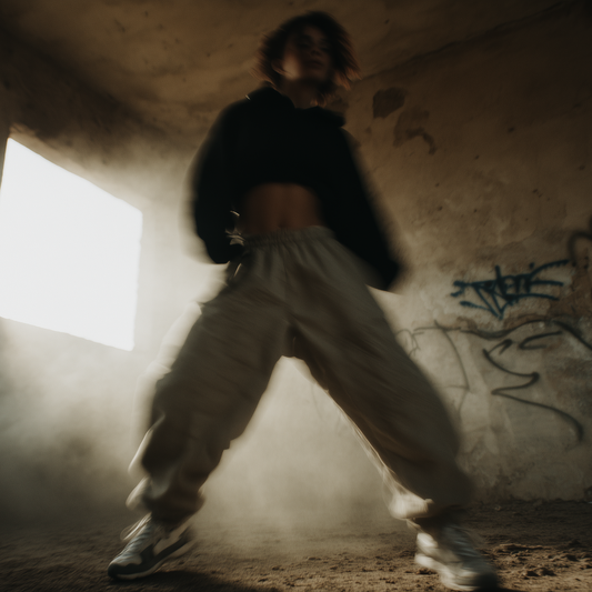 Person in a dark, graffiti-covered room with a light source creating a dramatic effect.
